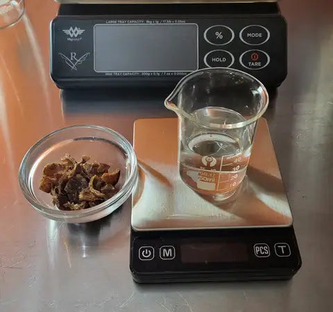 Ingredients for small batch bath and body products measured on a digital scale with a measuring cup and dish.
