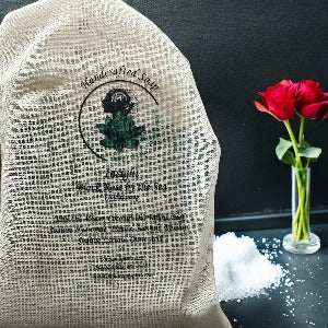 Handcrafted soap bag with the /my Unique Spirit logo, pile of sea salt and red roses in a glass vase.