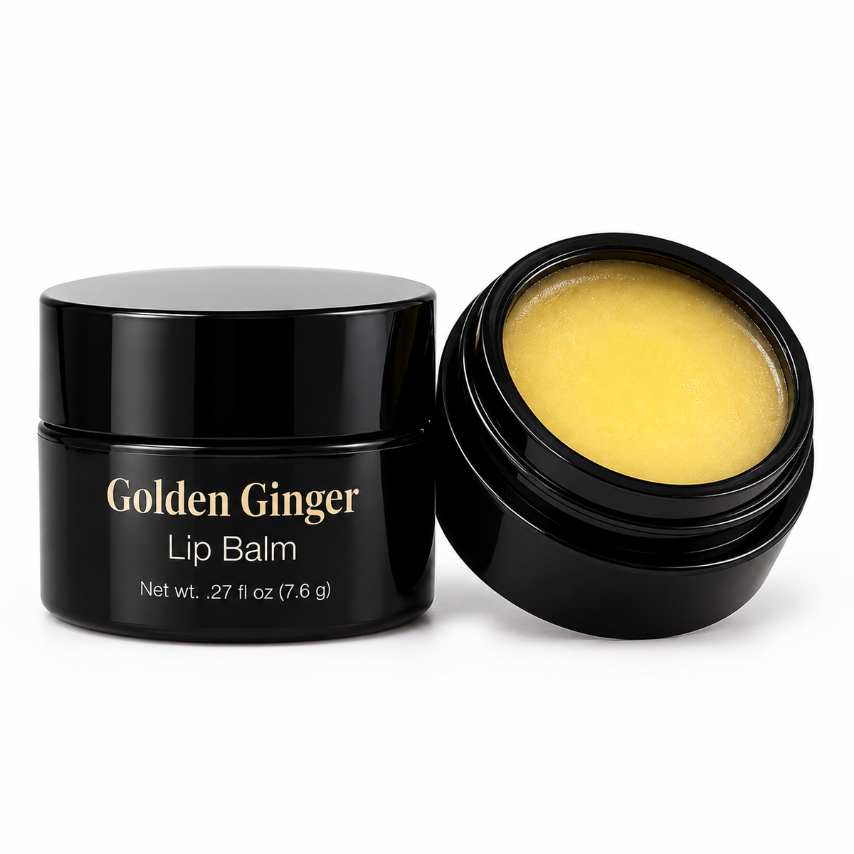 Black jar of MyUniqueSpirit Golden Ginger Lip Balm beside fresh ginger root and mango on a clean white background.
