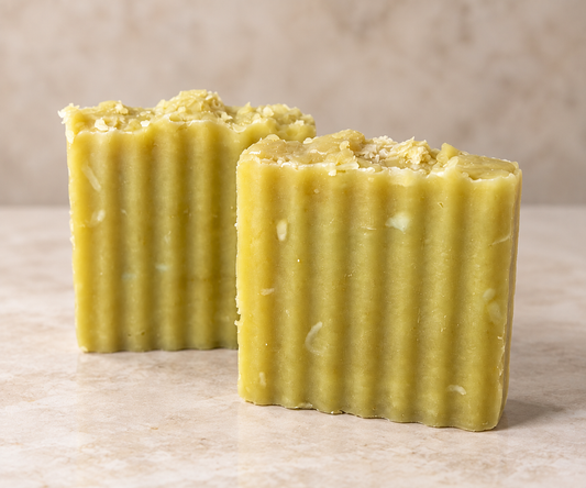 Two Summer Breeze handmade cleansing bars with natural pale yellow-green coloring and textured tops, displayed on a warm cream stone surface.